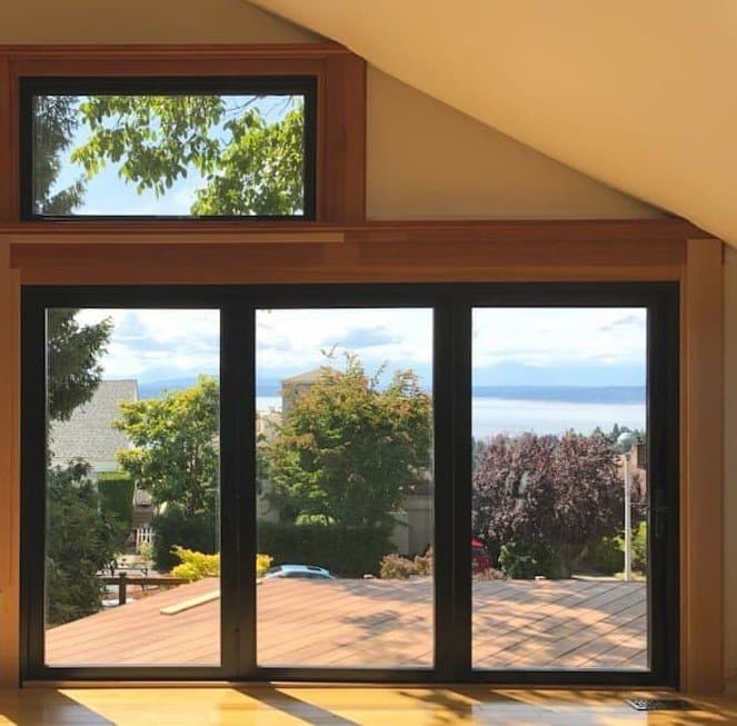 Black Bifold Patio Door For Craftsman Style Home Three panel black bifold patio door with stained wood trim
