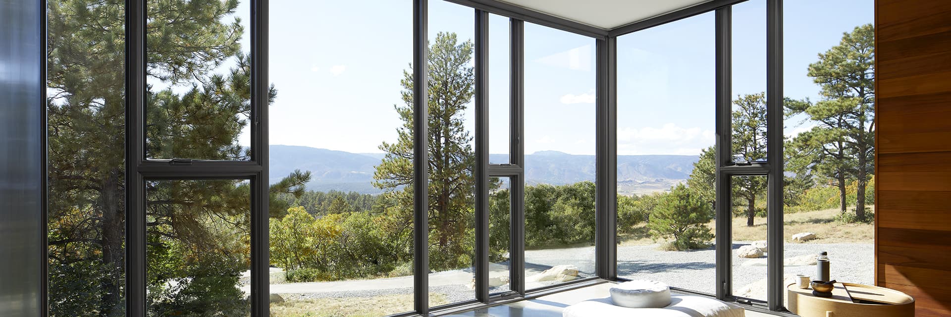 Large floor-to-ceiling windows and patio doors surround a home spa bringing the mountain scenescape views into the home.