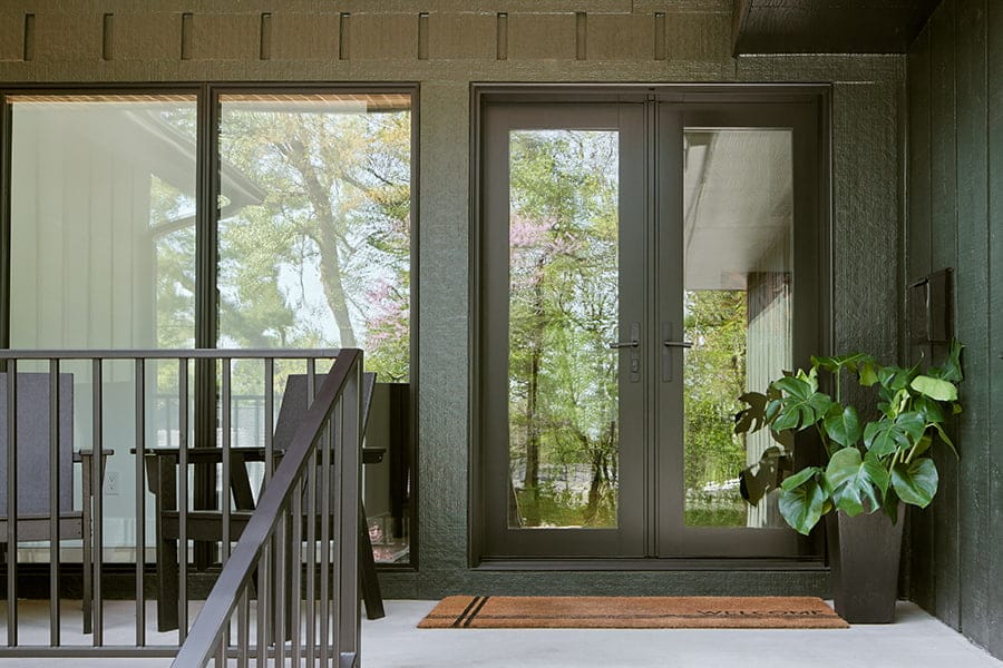 Two Story home with triple white window panes and double wood entry door