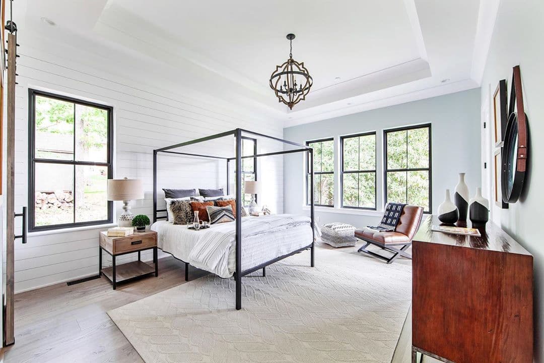 Cross Pattern Window Grilles Enhance Bedroom Window Design contemporary bedroom with four poster bed, chandelier, and black double-hung windows