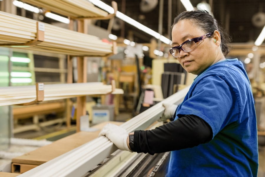 manufacturing employee using tools to assemble a window