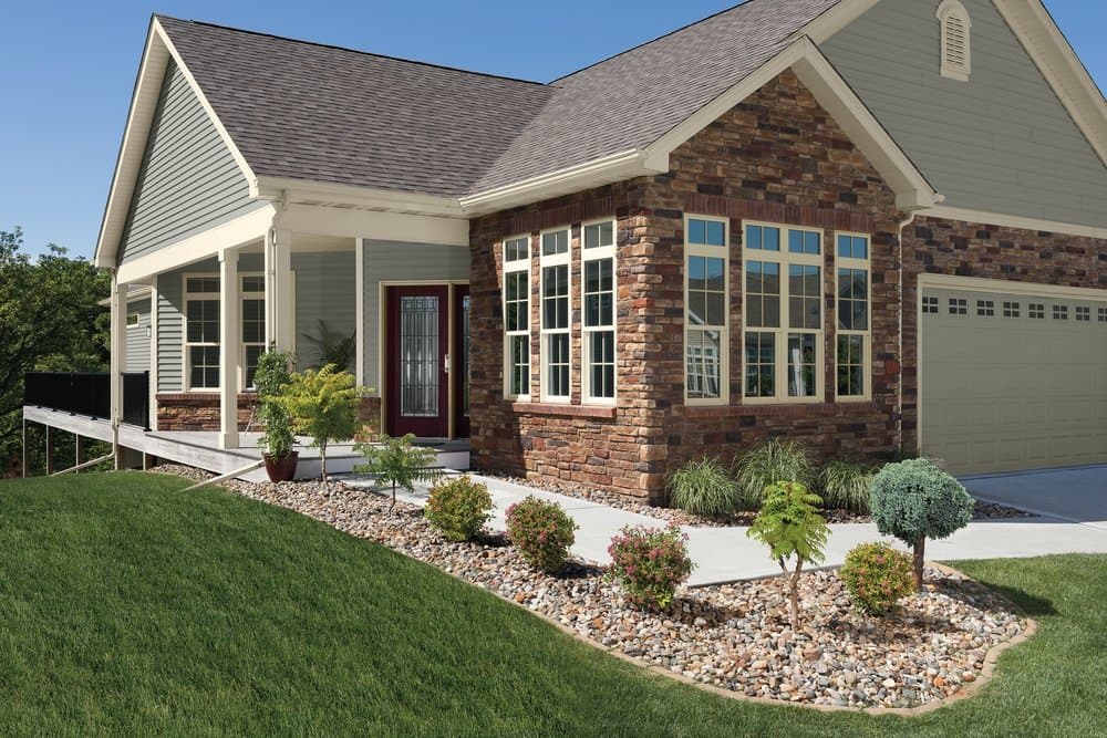 Tan Vinyl Windows Complement Traditional Home Design Traditional style home with brown brick, green siding, and tan vinyl windows