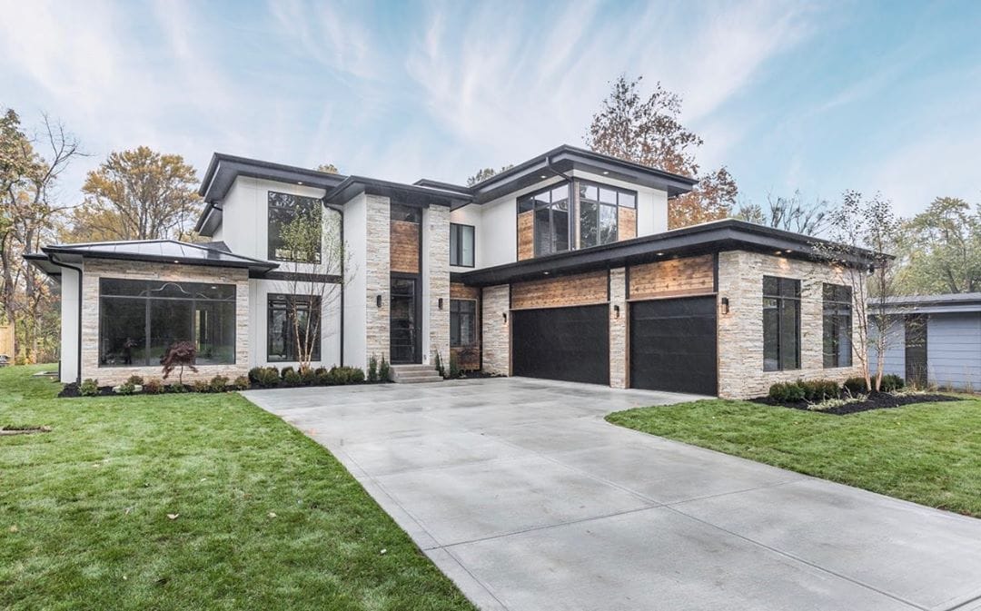 Black Windows Accent This Home's Modern Design modern home featuring a mix of tan stone, white stucco, and black accents including black windows