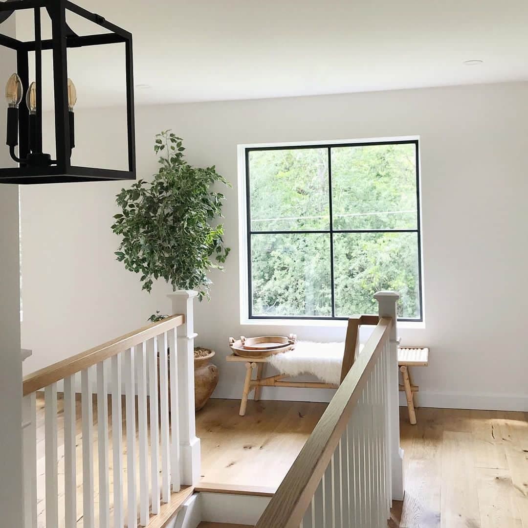 Minimal Black Frames On Fiberglass Window Enhances Design black picture window with a bench underneath at the top of stairs