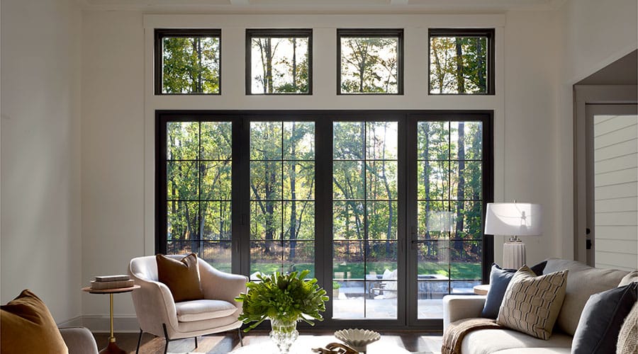Modern living room with black bifold glass doors and natural light.
