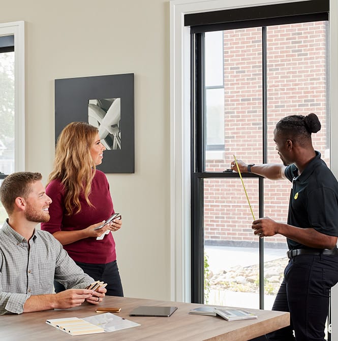 Consultation in Chicago with a professional measuring a window in a modern interior.