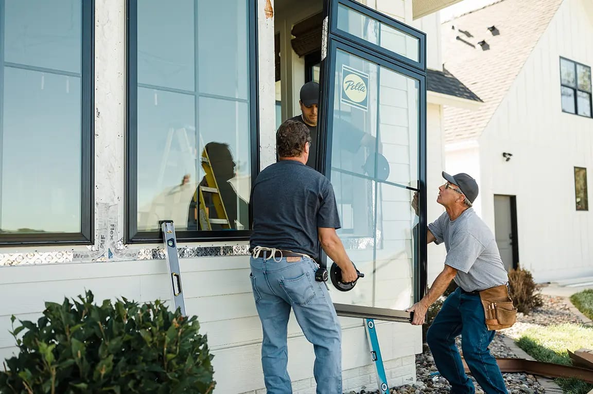 two installers replacing two double-hung windows with new Pella windows