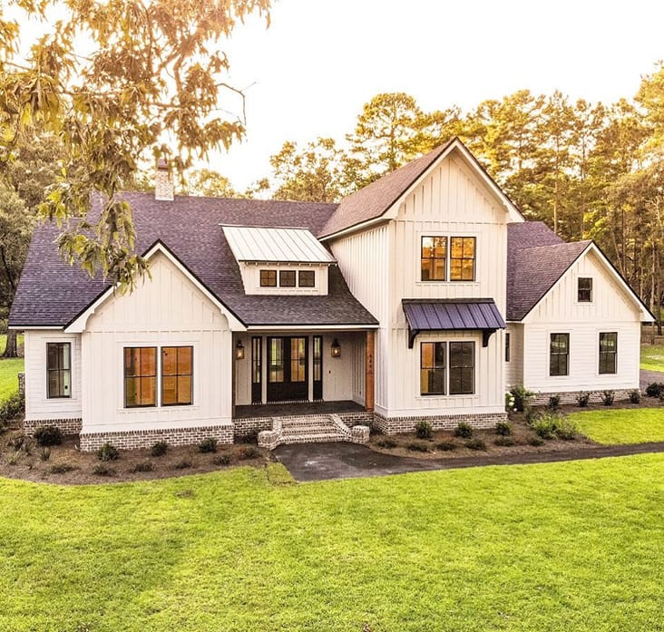 Double-Hung Windows Bring Charm To Modern Farmhouse white modern farmhouse exterior with black double-hung windows and black front door