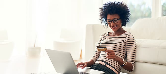 a woman sits on the floor with her laptop shopping for new windows