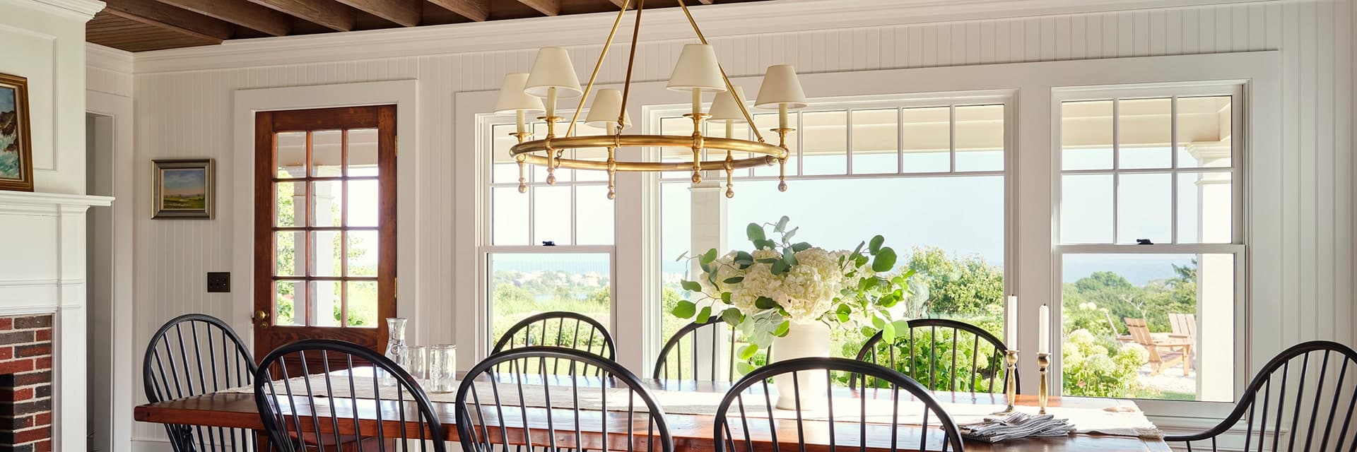 Dining room windows and patio door overlooking waterfront views.