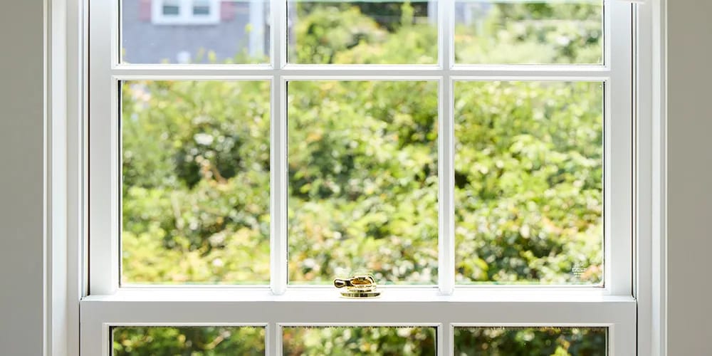 Several white double-hung windows with brass spoon locks.