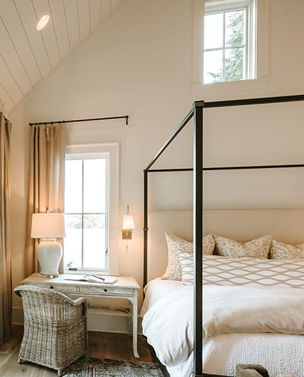 Elegant bedroom featuring a traditional window overlooking the outside from the upstairs.