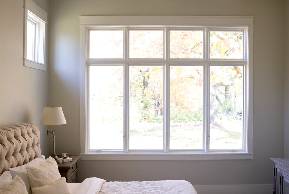 Classic Casement Windows For Traditional Bedroom Row of four white windows with white trim in beige bedroom