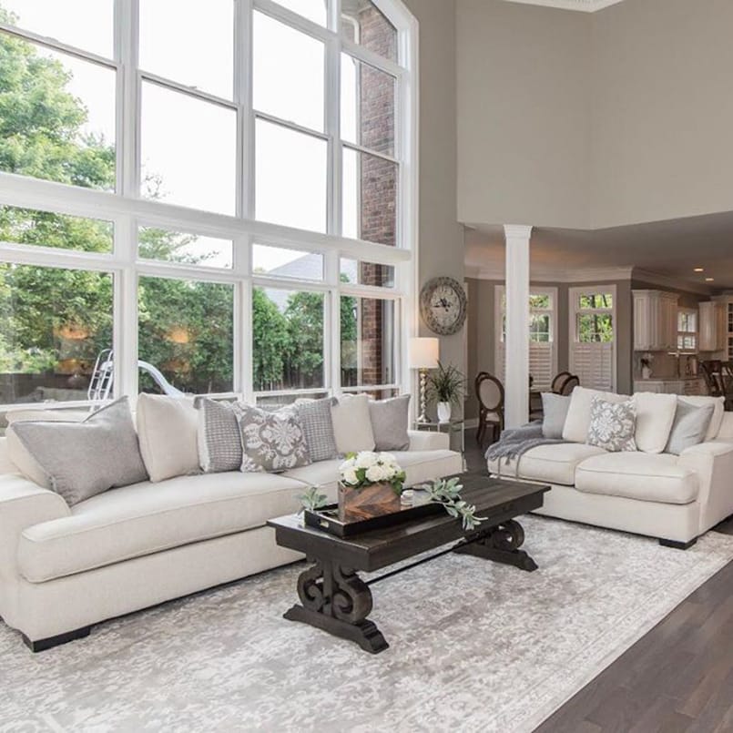 Fixed & Operable Windows Create Contemporary Wall Of Glass Neutral colored living room with white couches in front of floor-to-ceiling glass windows