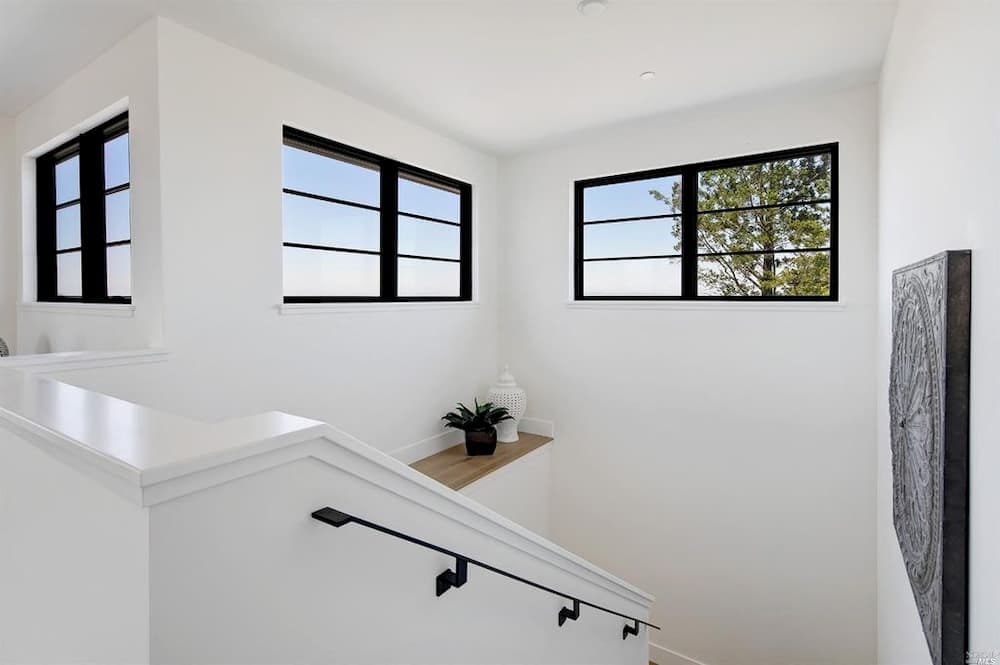 Black Window Grilles Emphasize Clean Lines In Modern Home Modern black windows situated high up in white stairway