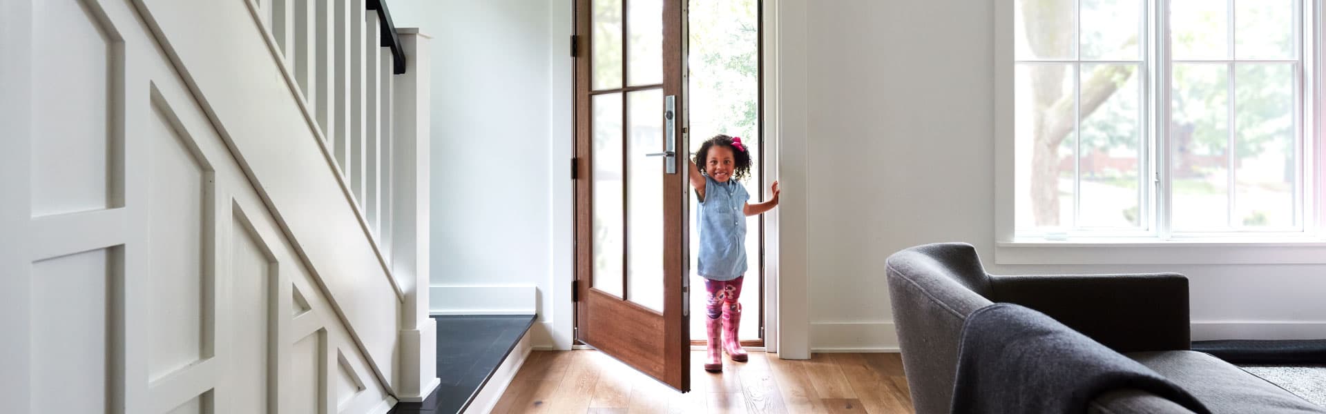 young girl walking through a pella entry door with glass