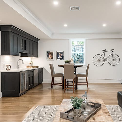 An egress window behind a small table in a basement kitchenette