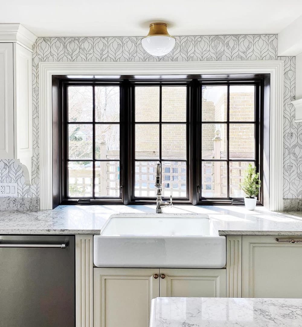A black kitchen box window features two casement windows with a picture window in the middle.