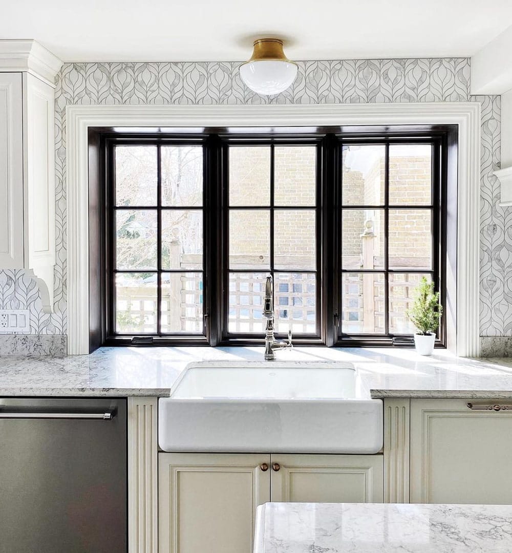 A black kitchen box window features two casement windows with a picture window in the middle.