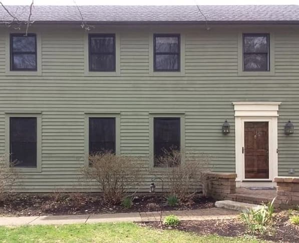 Curbside view of colonial style home with outdated windows.