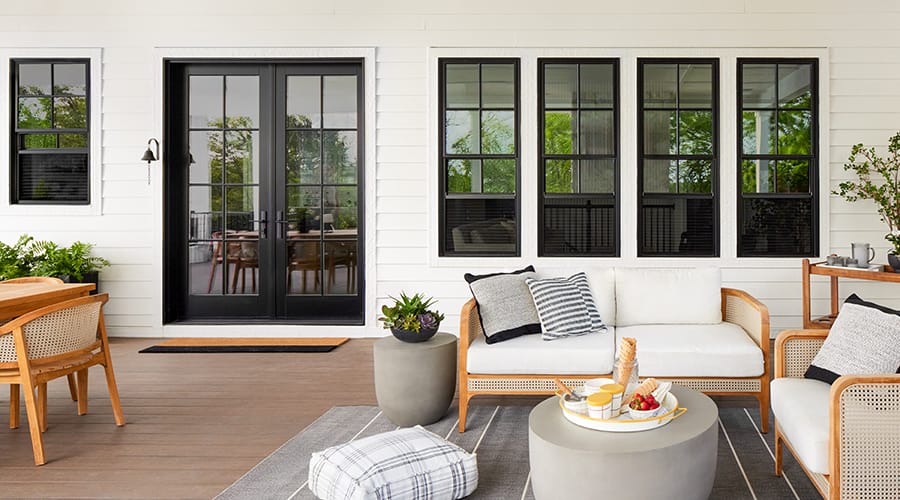Black double hung windows on patio of home.