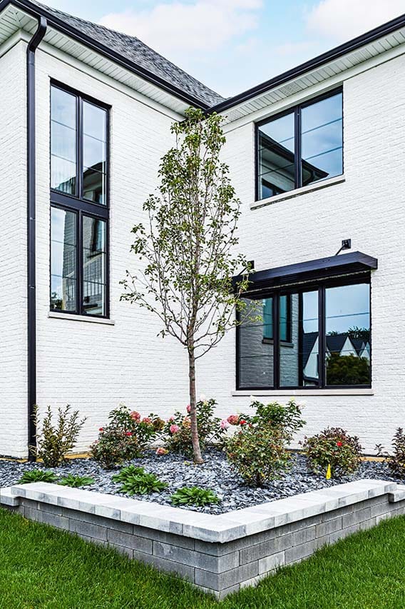 Black-framed windows set into a white brick home exterior.