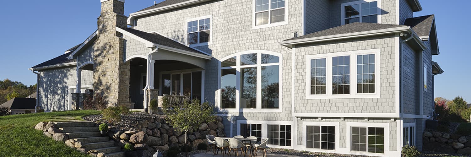 large new construction home exterior with vinyl windows and hidden screens