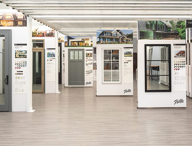 Window and door showroom with rows of display panels showing modern windows, exterior doors, and finish samples