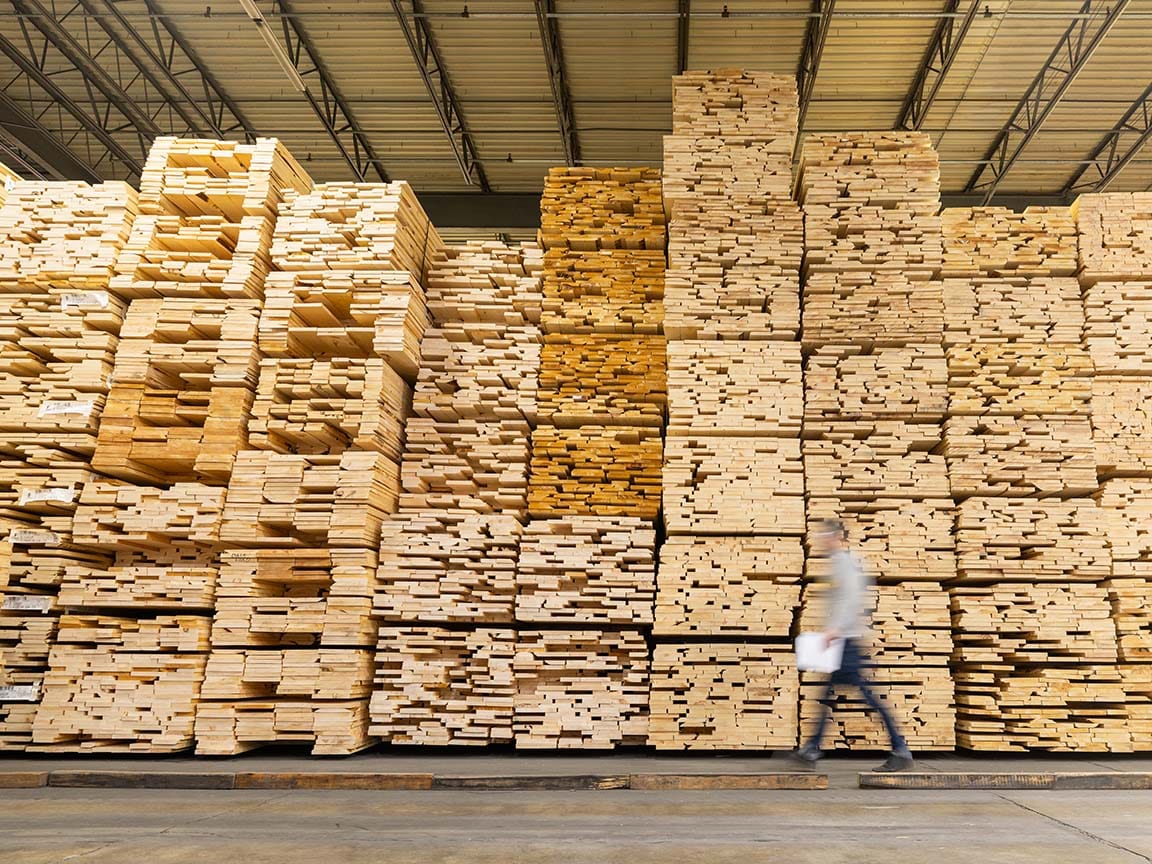 Stacks of lumber inside a window manufacturing facility used for wood window production.