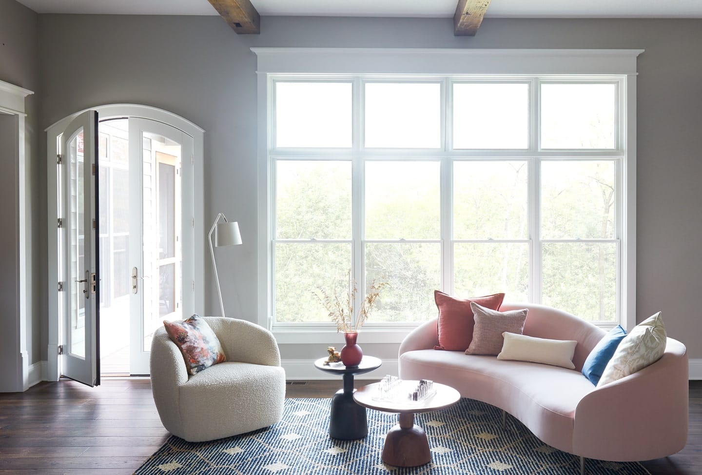 living room with pella reserve windows and arched two-panel hinged door