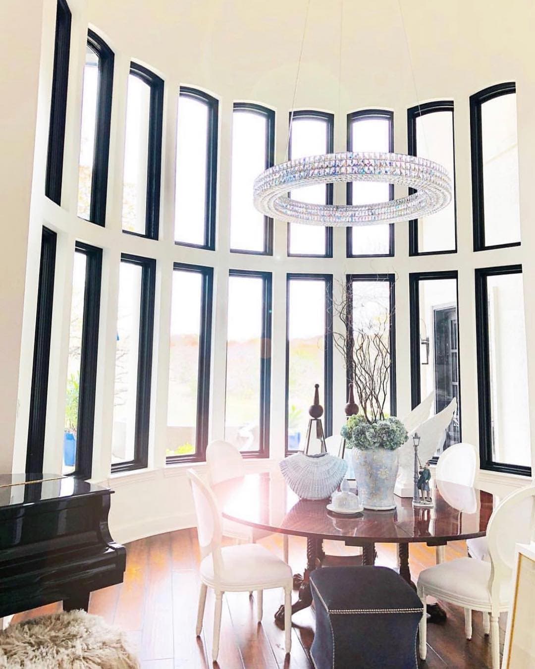 Black Fixed Windows Emphasize Elegant Curved Wall curved wall filled with black casement windows in a dining room