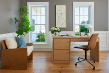 Two white fiberglass windows behind a home office desk.