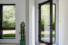 Pella Reserve fixed and casement windows on a white contemporary home exterior wall.