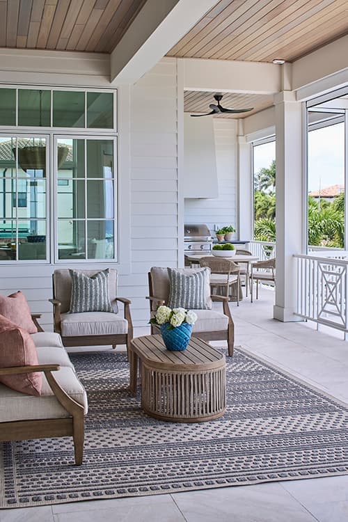 A white home with a large deck that surrounds the front of the home.