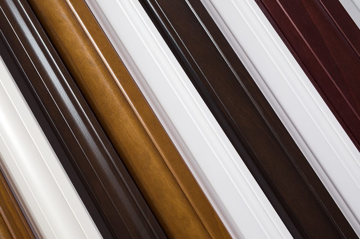 A collection of interior window trim samples in various colors and wood materials.