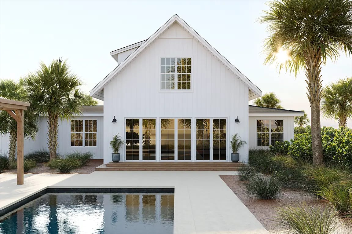 Sunlit white modern coastal farmhouse with floor-to-ceiling glass doors, backyard swimming pool, and palm trees