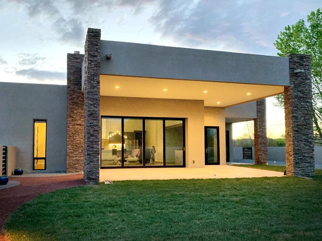 Black Sliding Patio Door Complements Minimalist Design backyard of modern stone home with black sliding patio door