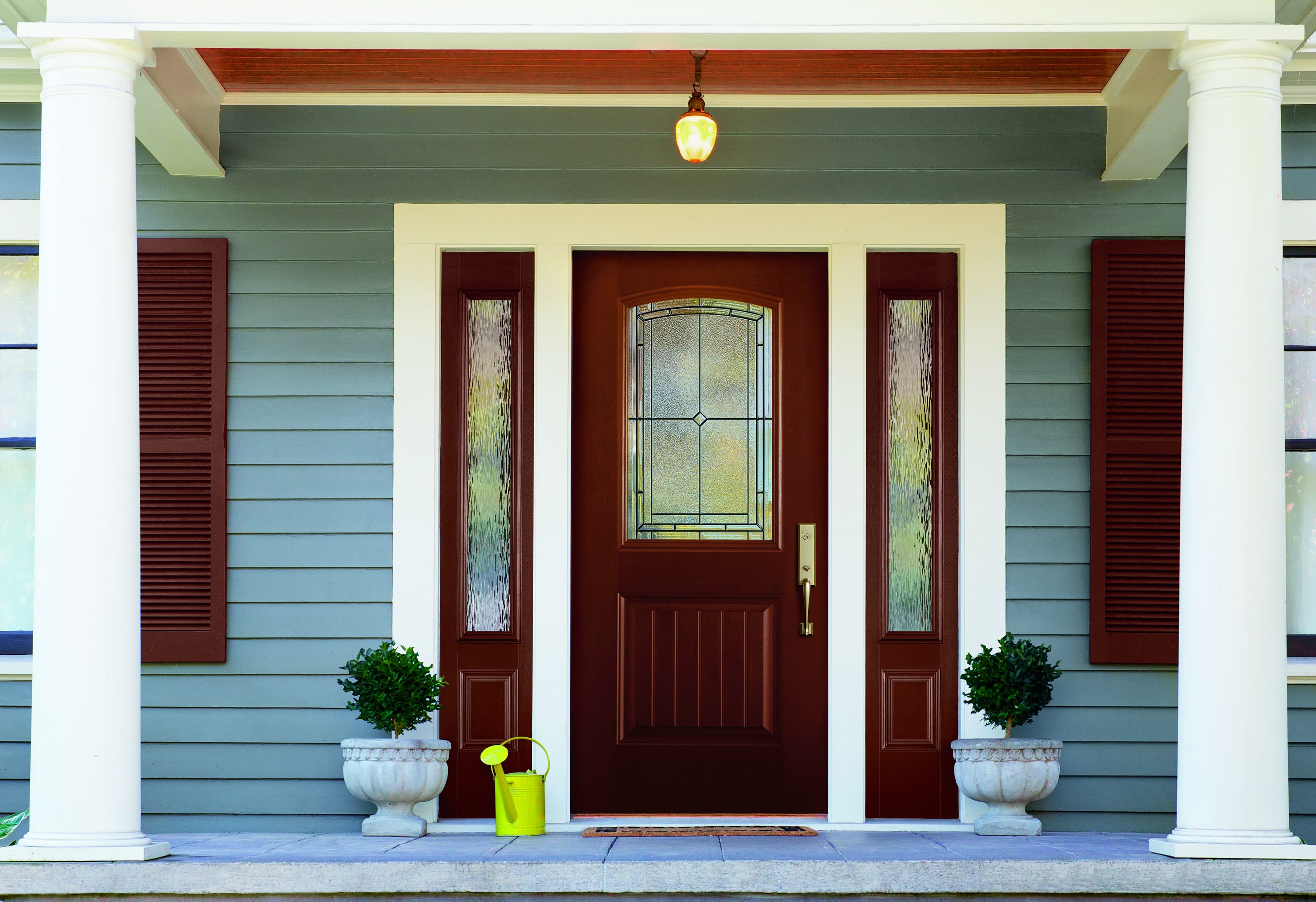 Fiberglass Front Door Sidelights Create Entryway Focal Point Mahogany color door with decorative glass and sidelights on blue house