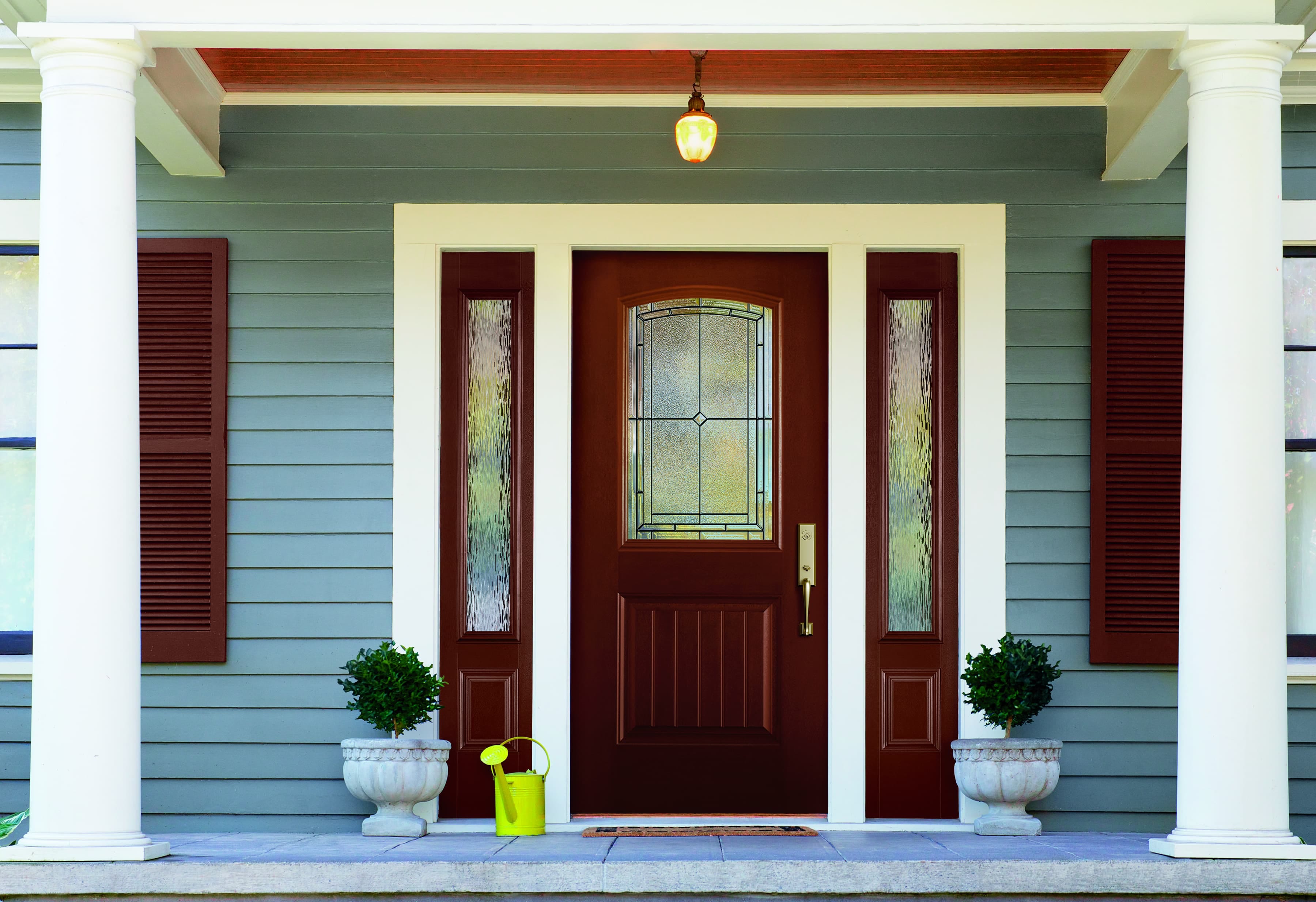 Fiberglass Front Door Sidelights Create Entryway Focal Point Mahogany color door with decorative glass and sidelights on blue house