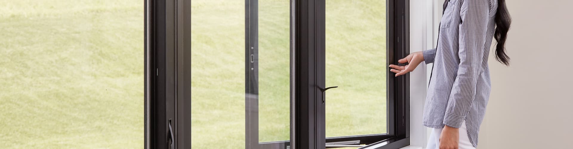 woman in striped shirt using an easy slide operator on a casement window