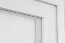 The corner of a white Pella 350 Series vinyl window featuring the removal of a raised weld.