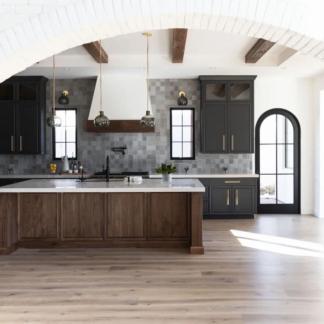 A rustic modern kitchen features black windows and gray cabinets.