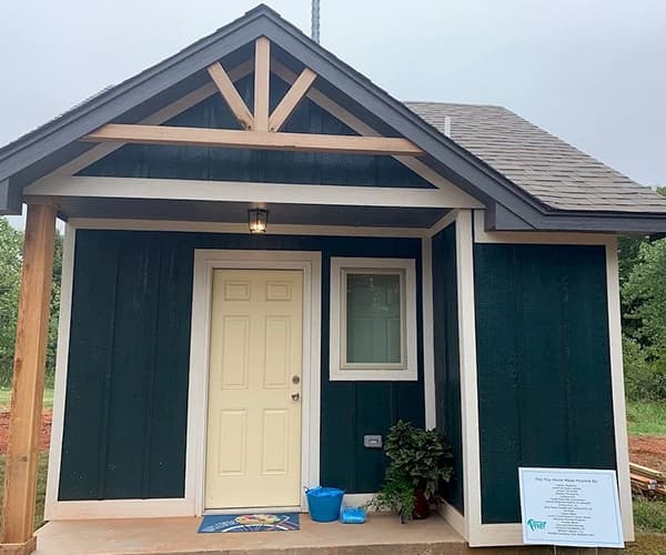 a dark blue tiny home that is set aside for homeless youth