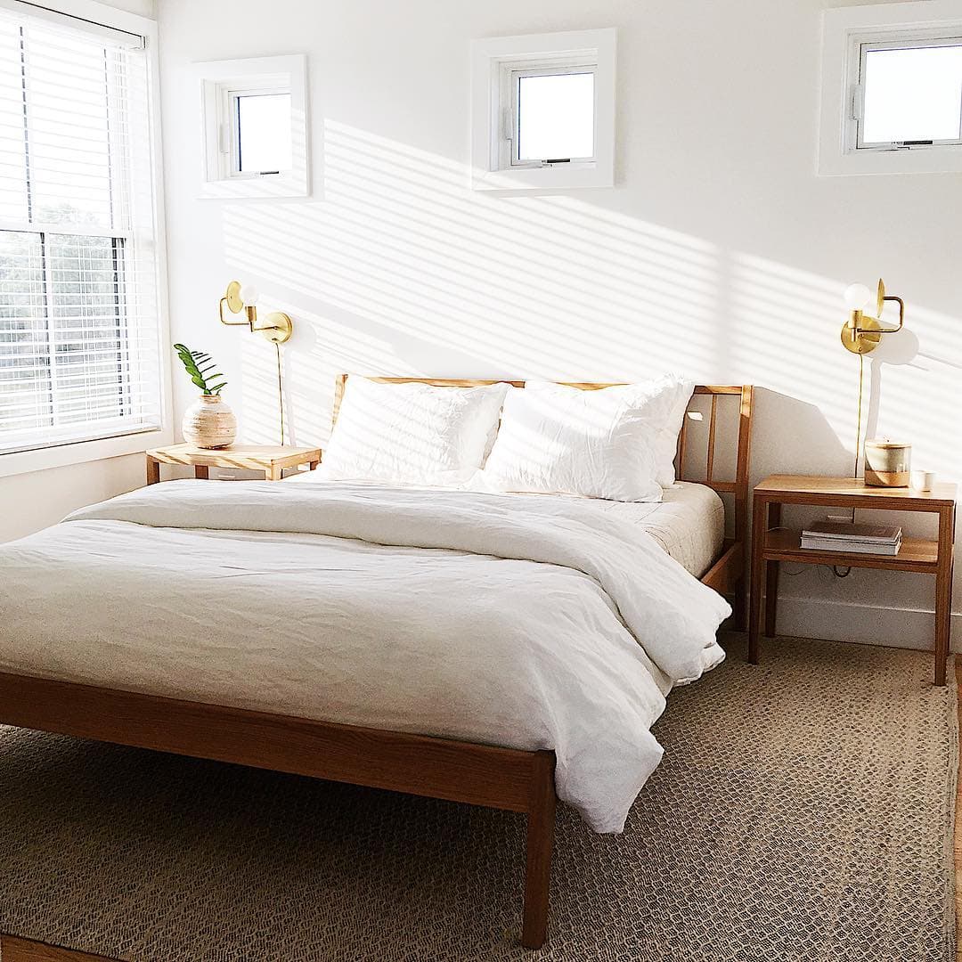 White Windows In Simple & Serene Bedroom light streaming into white bedroom through large double-hung window with three square windows above bed