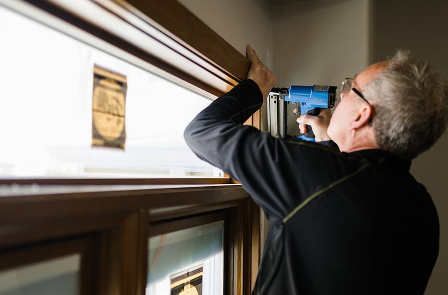 the final touches of installing a transom over a new front entry door