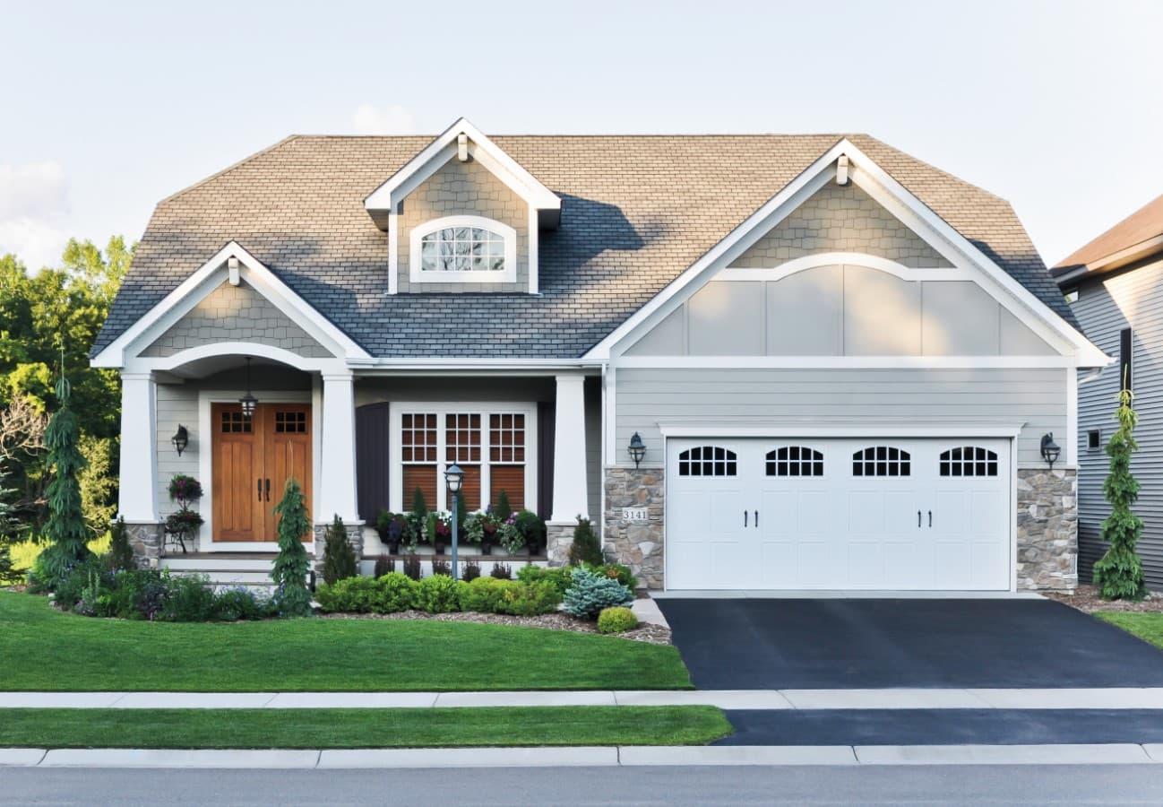 Craftsman style home with double-hung windows and wood double door