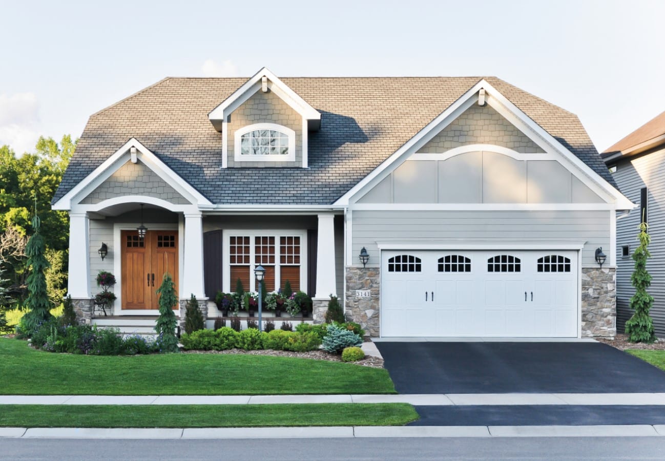 Craftsman style home with double-hung windows and wood double door