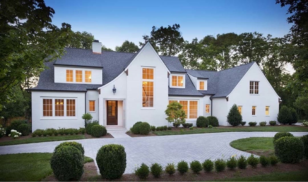 Classic White Casement Windows for Traditional Home white tudor inspired home with black windows and lush greenery