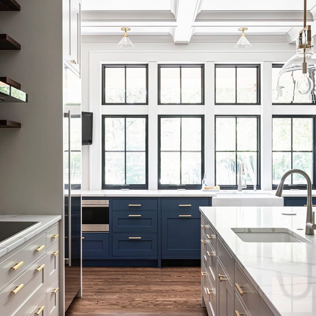 Modern Farmhouse Kitchen Enhanced By Wall Of Black Windows Two rows of black windows with grilles illuminates modern farmhouse kitchen