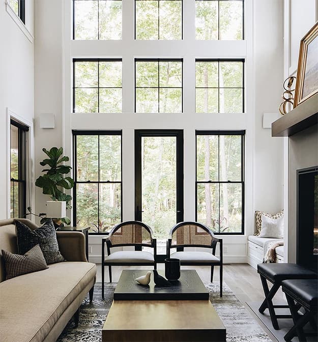 black windows are stacked from floor-to-ceiling around a full light hinged door